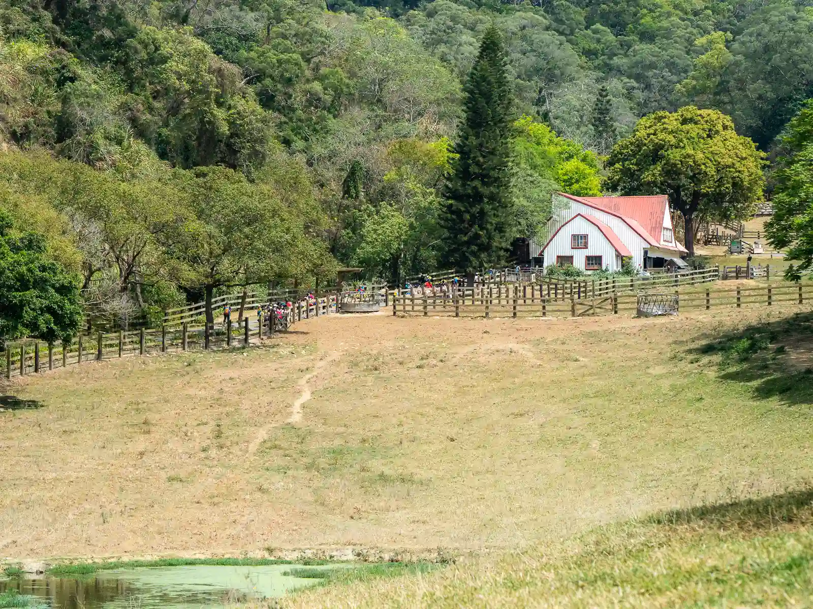 Walking paths lead to a farmhouse in the distance.