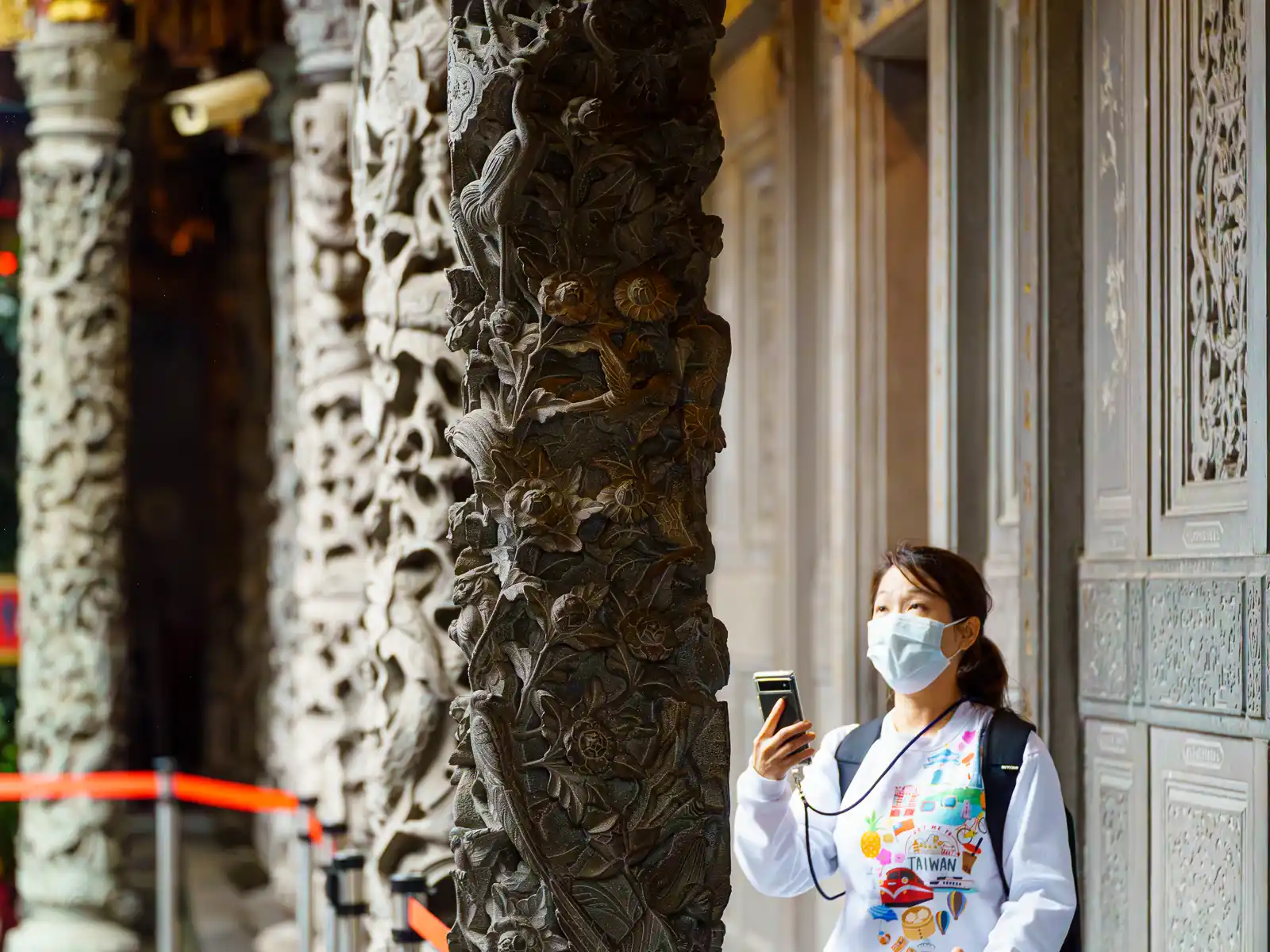 A tourist takes a photo of a carved column at Qingshui Zushi Temple.