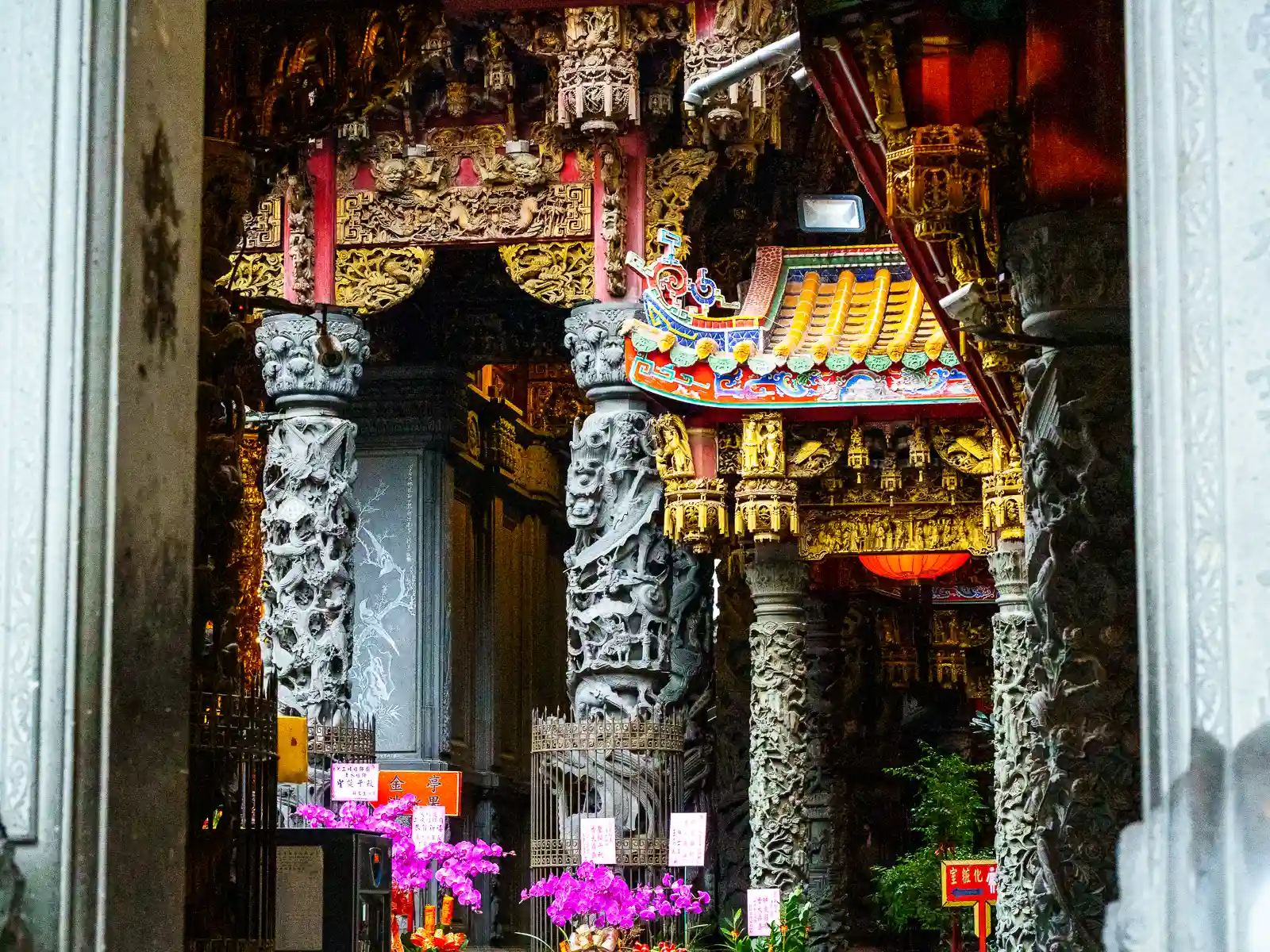 Multiple rows of carved columns, carved awnings, and roof carvings are seen in this shot of the interior of the temple.