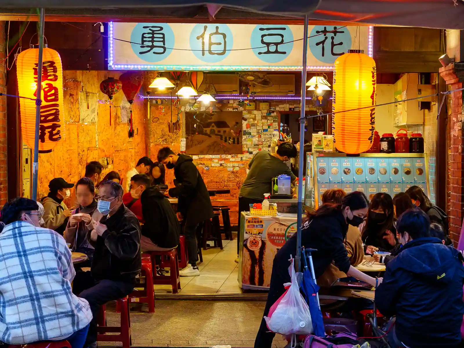 A shop selling tofu pudding is packed with customers.