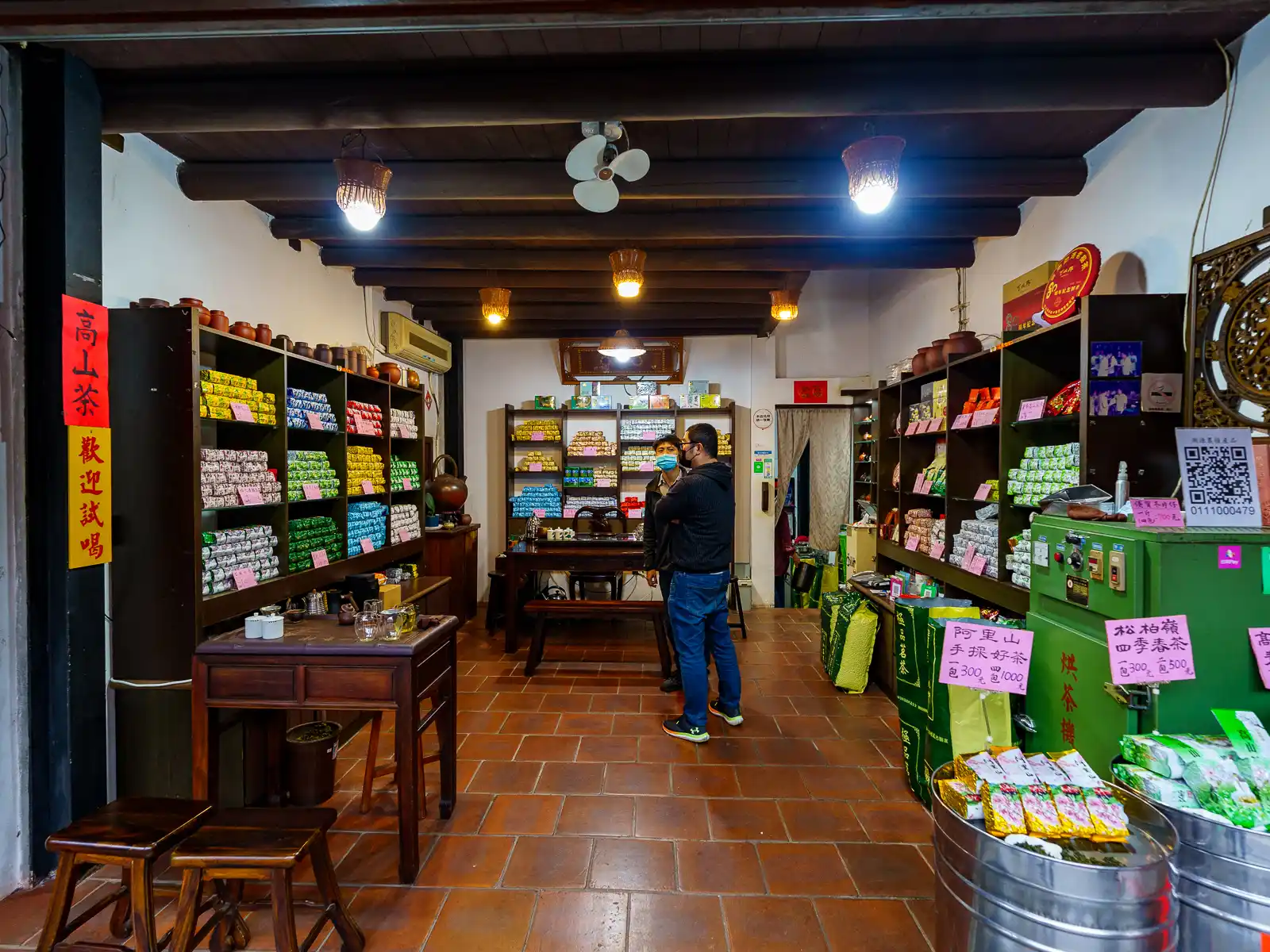 High mountain tea is lines the walls of a first floor shop with a simple interior.