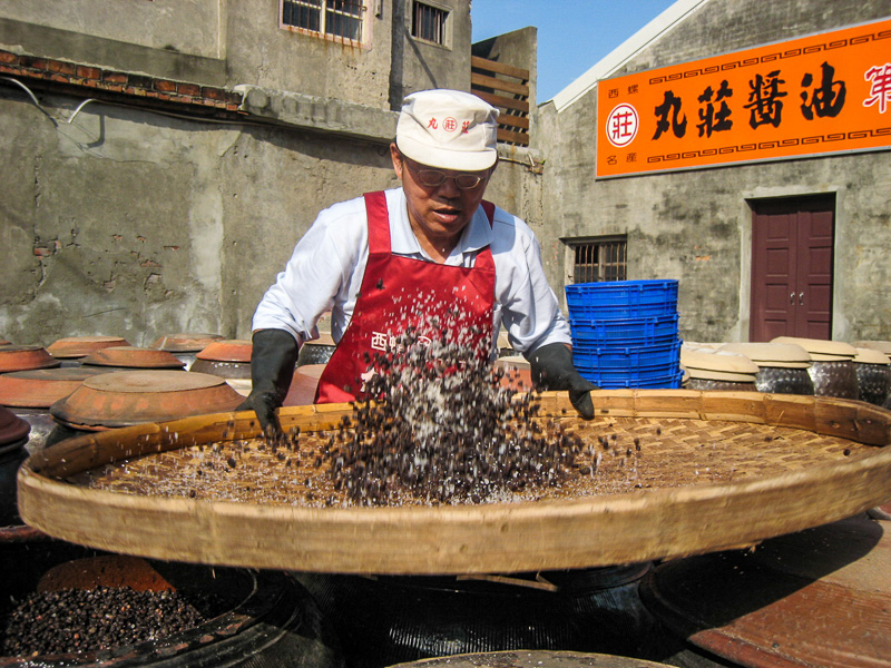 A Wuan Chuang Soy Sauce employee mixes the soy beans during the soy sauce production process.