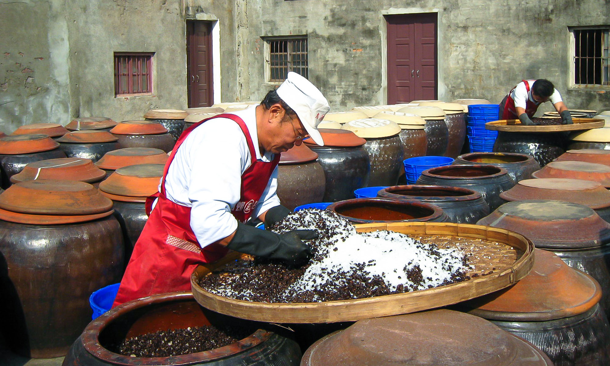 Soy sauce is prepared for the outdoor fermentation stage at the Wuan Chuang Soy Sauce Factory.