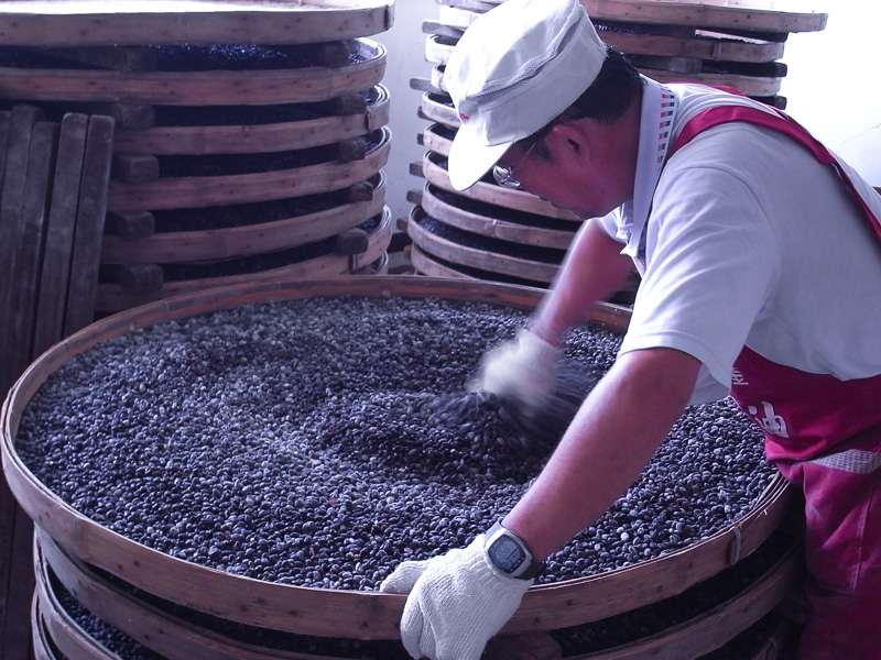 A Wuan Chuang Soy Sauce employee mixes the soy beans during the soy sauce production process.