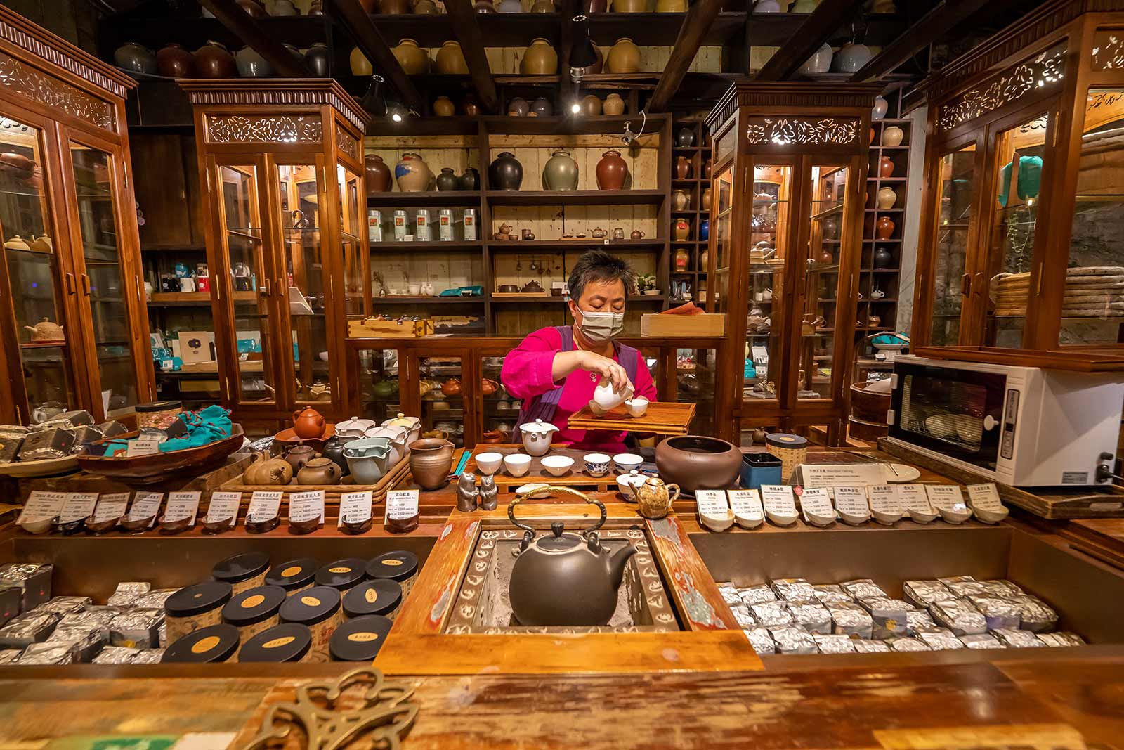 An employee in a very well stocked tea shop in Jiufen demonstrates proper tea brewing procedure.