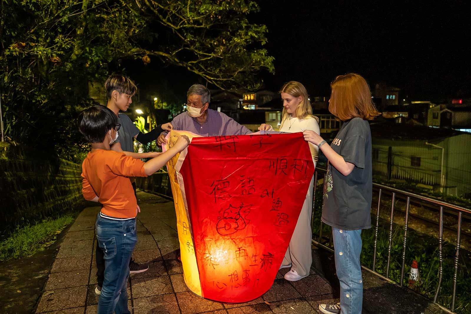 A family prepares to send off their customized sky lantern.