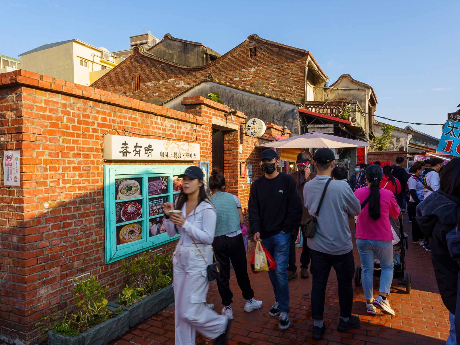 Tourists walk down a red-brick alley in Lukang.