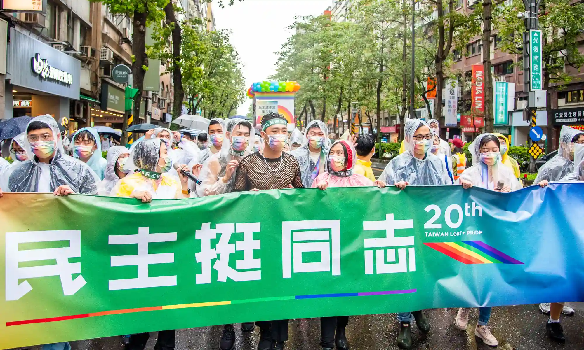 Marchers hold a banner that reads "Democracy supports Pride".