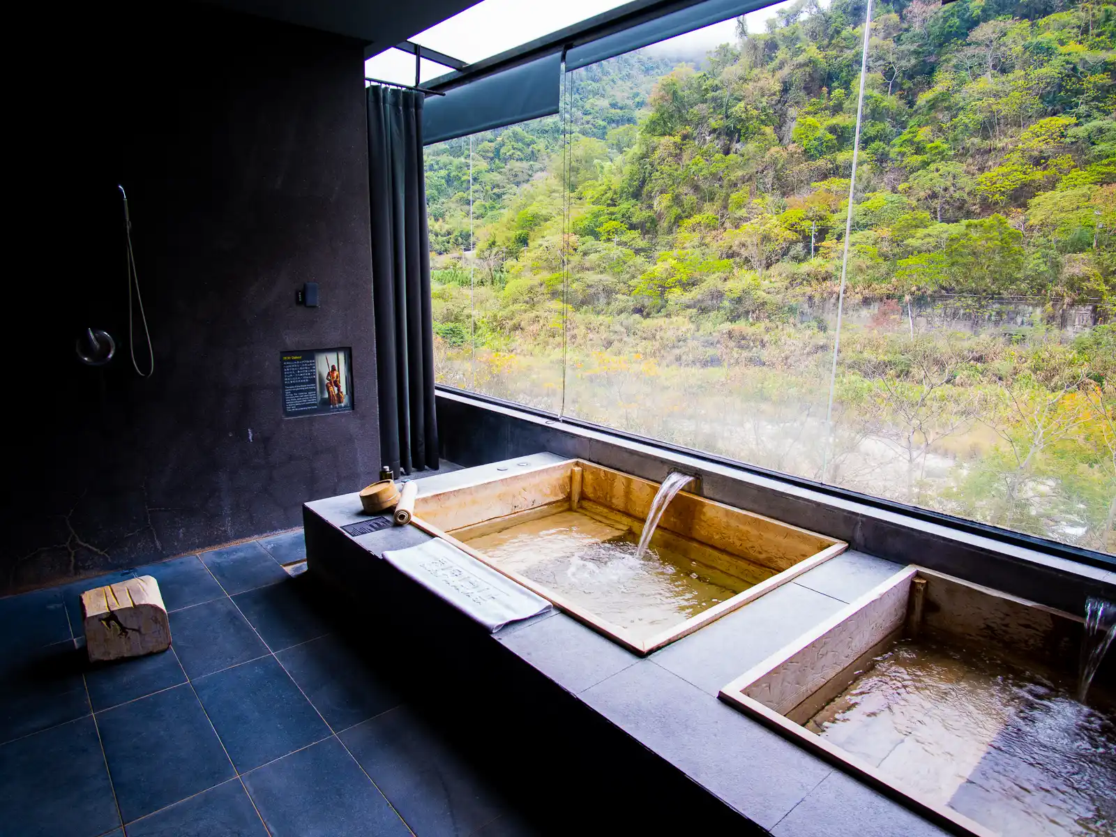 A private indoor hot spring features a view of the river valley below.