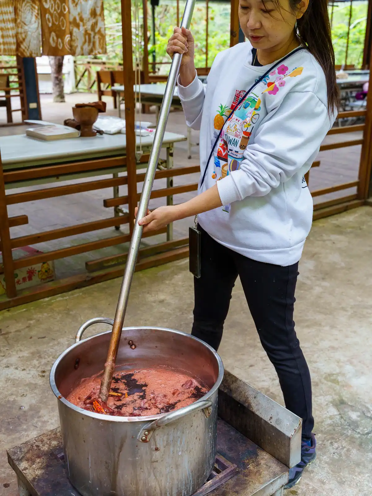 A student mixes a pot of dye.