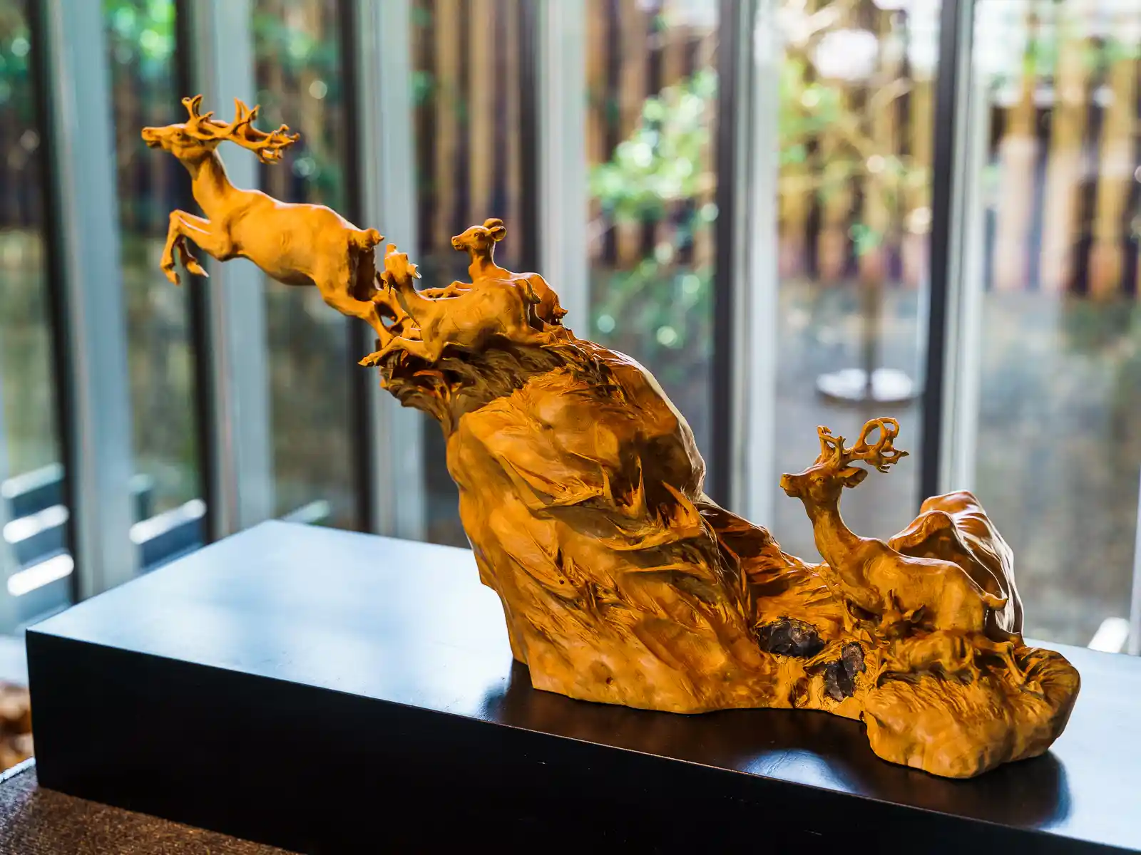 An extremely detailed abstract woodcarving of several deer.