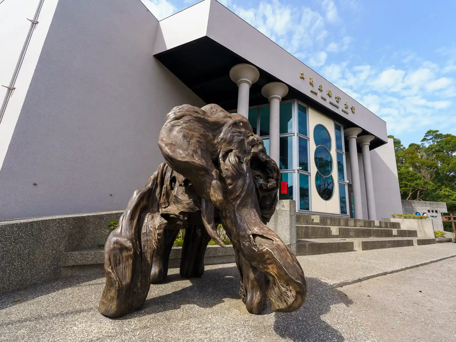 A large wood carving of an elephant stands at the entrance to the museum.