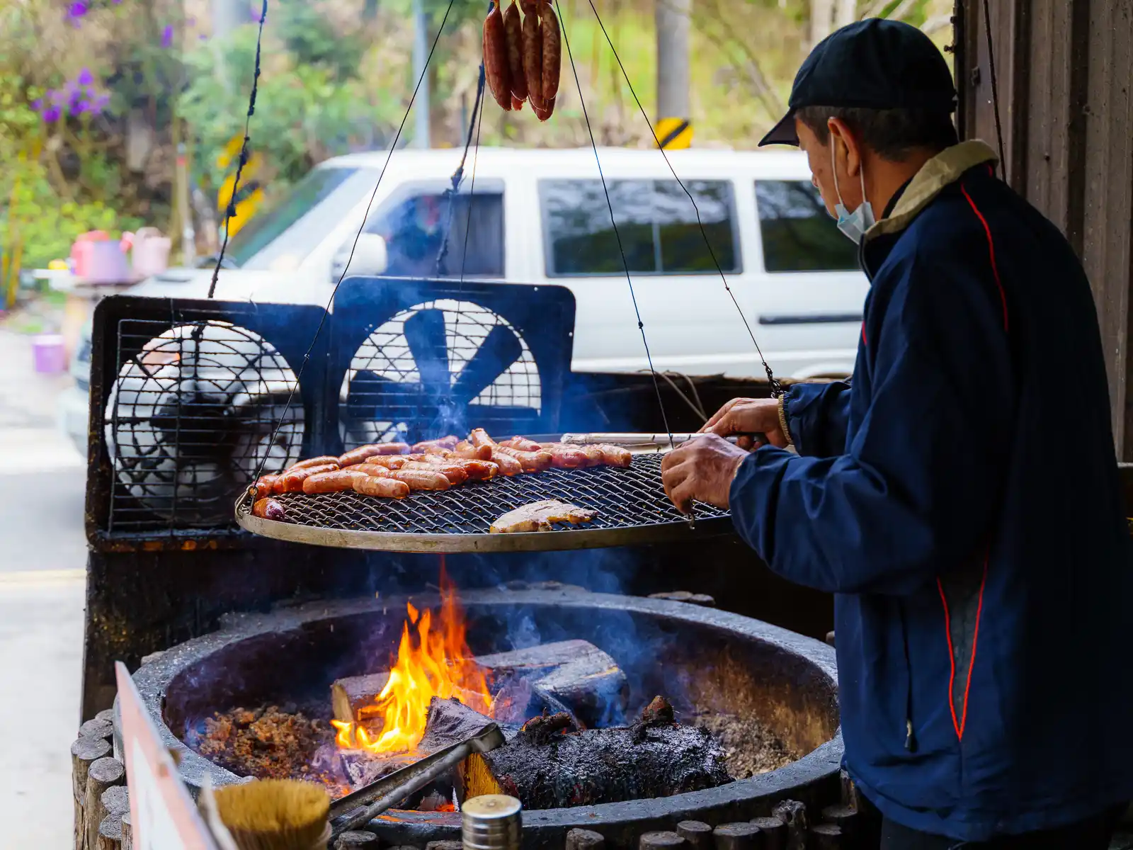 An indigenous vendor sells sausages nearby.