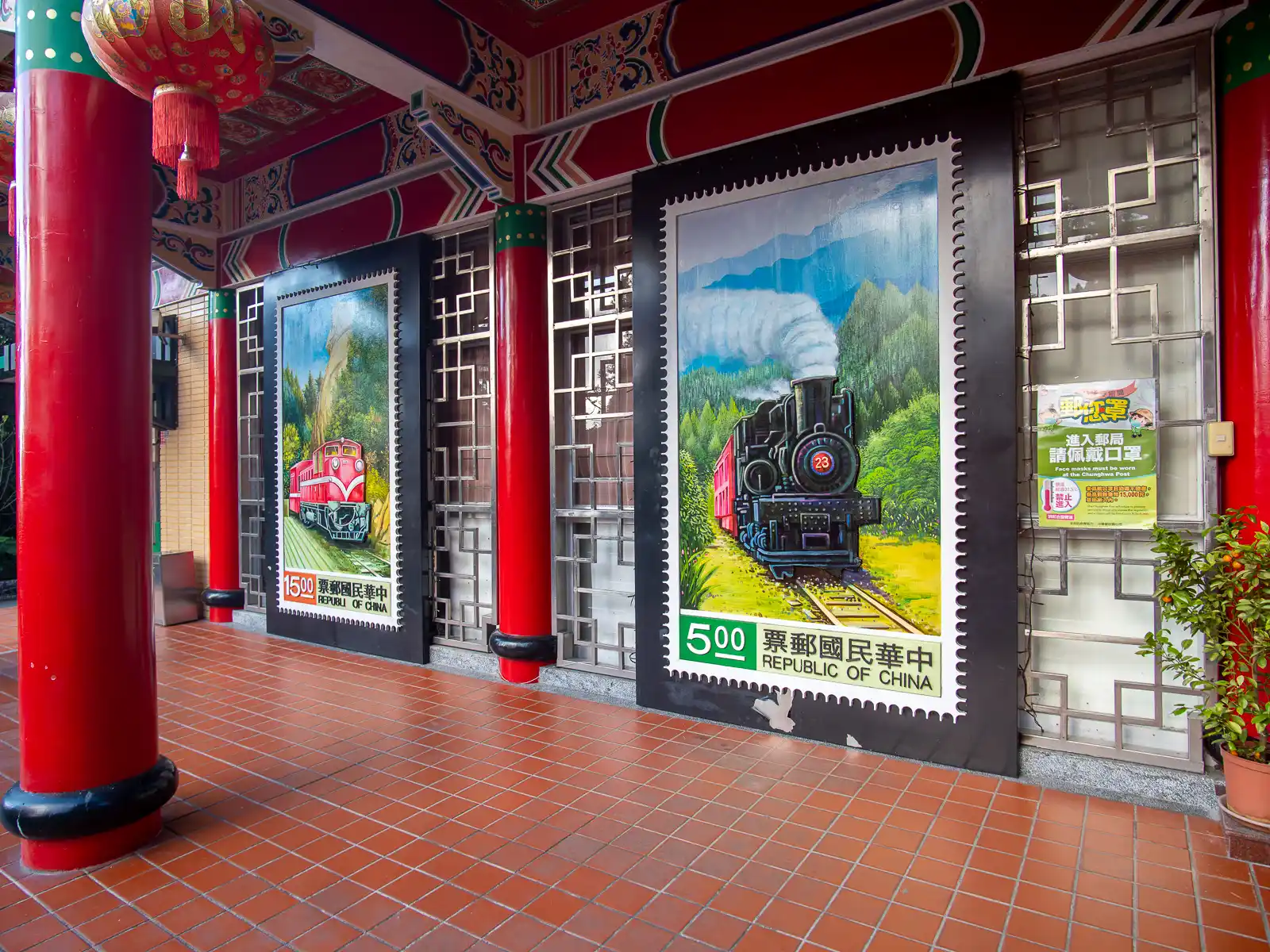 A colorful mural depicting a stamp celebrating the Alishan Forest Railway is visible on the wall of the Alishan Post Office.