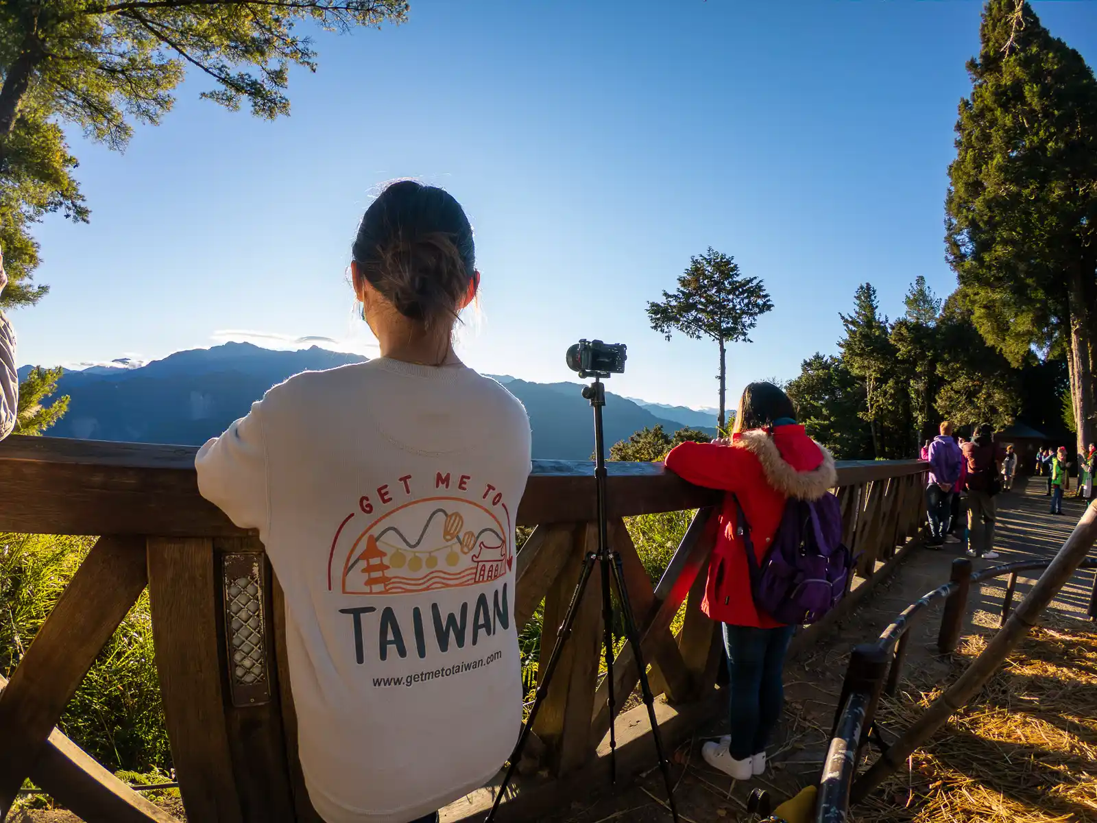 Visitors enjoying a view of the Jade Mountain Range from a viewpoint in Alishan National Forest Recreation Area.