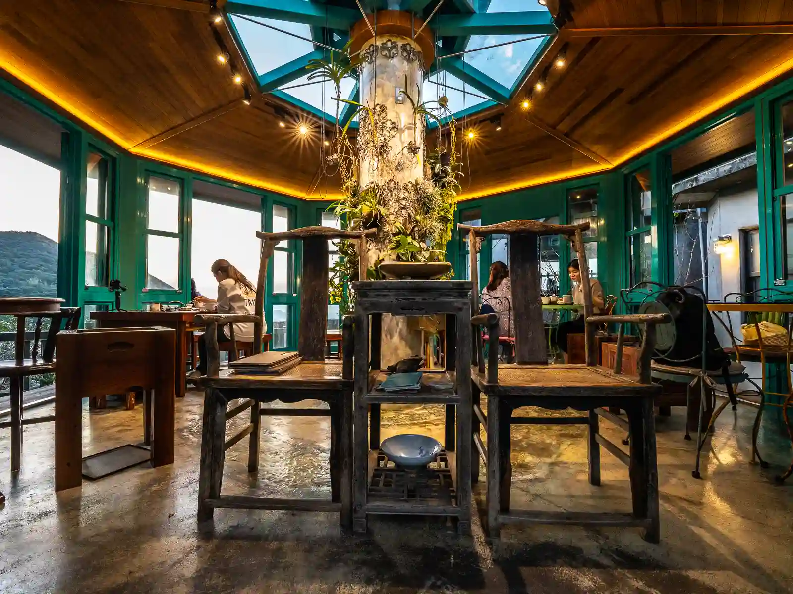 The covered pavilion seating area of Jiufen Tea House is round and surrounded with floor-to-ceiling glass windows.