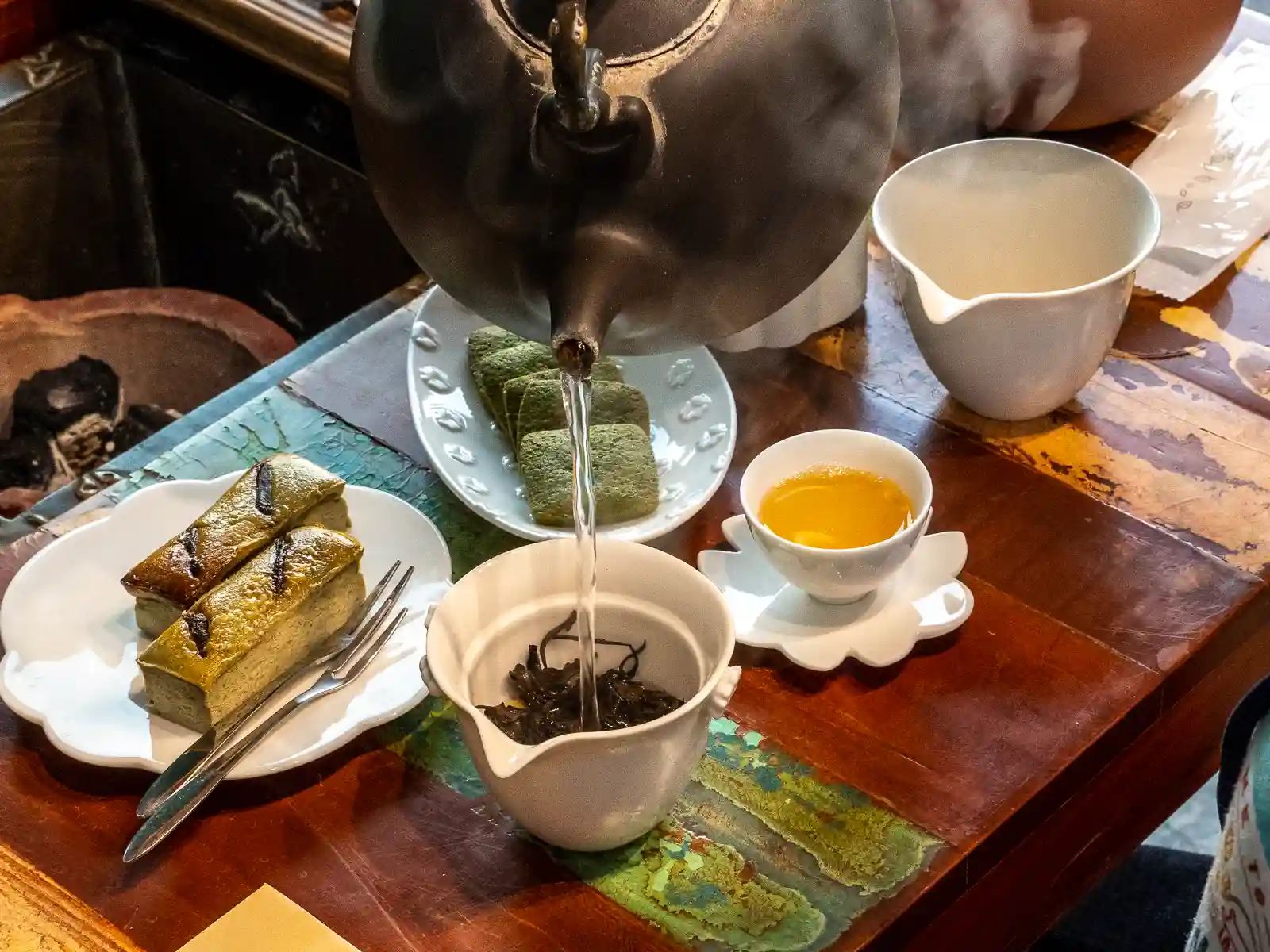 A tea set and plates filled with cookies and cakes at Jiufen Tea House.