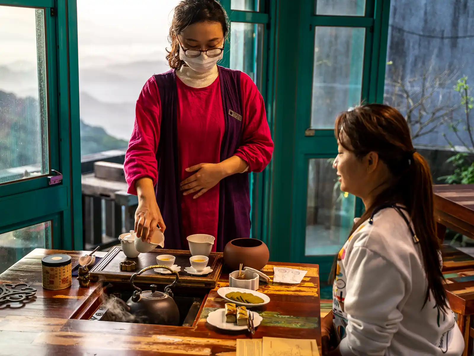 An employee pours tea for a guest at Jiufen Tea House.