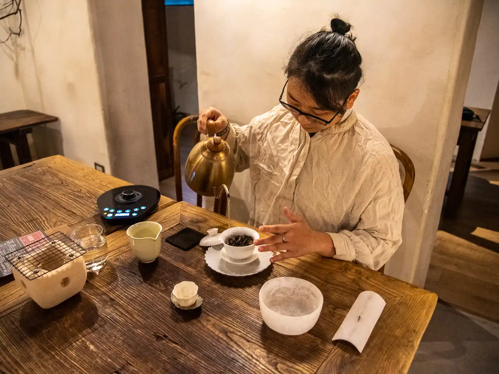 An employee demonstrating how to properly brew tea leaves.