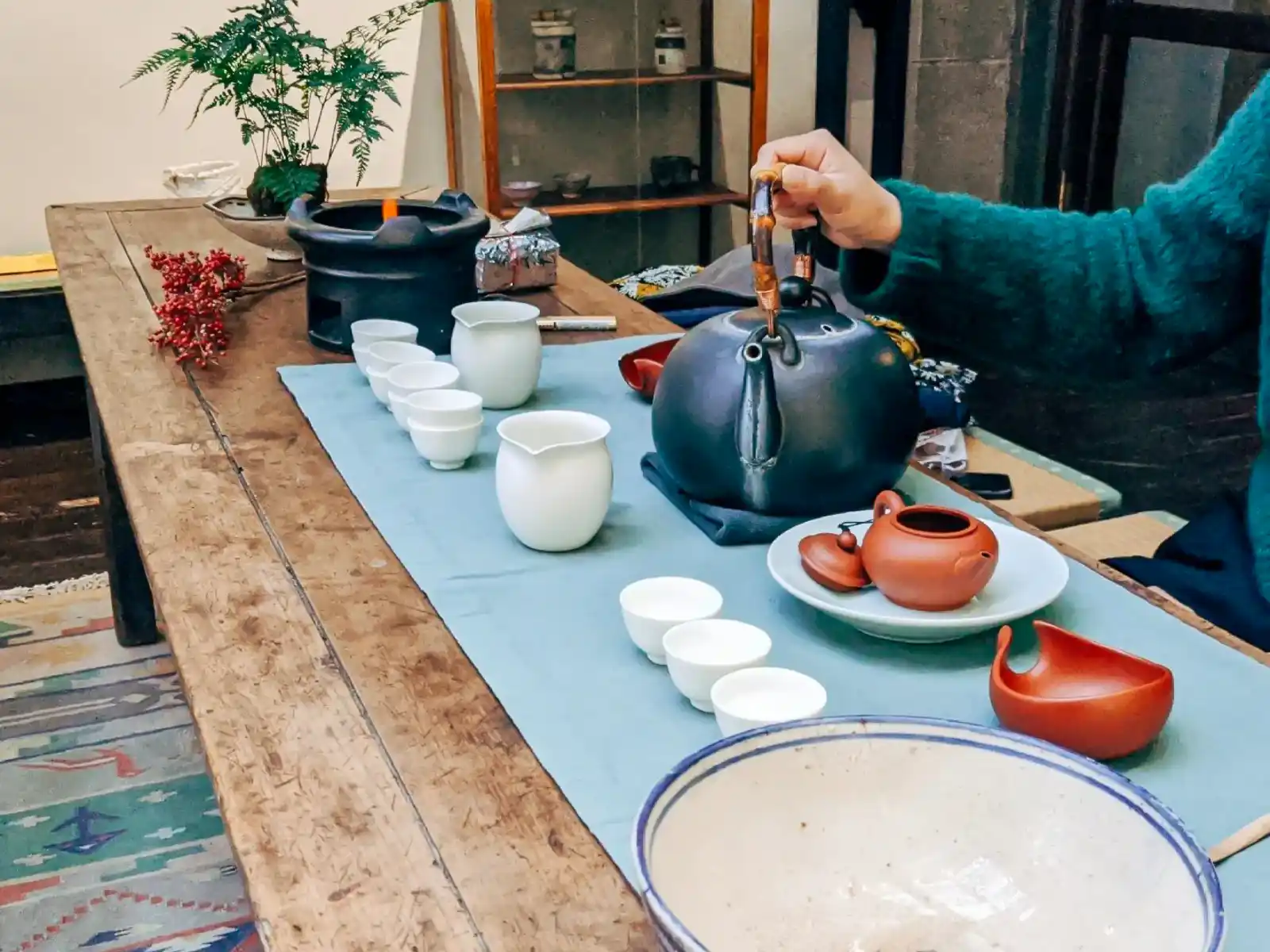 A full tea set on display on a wooden bench.