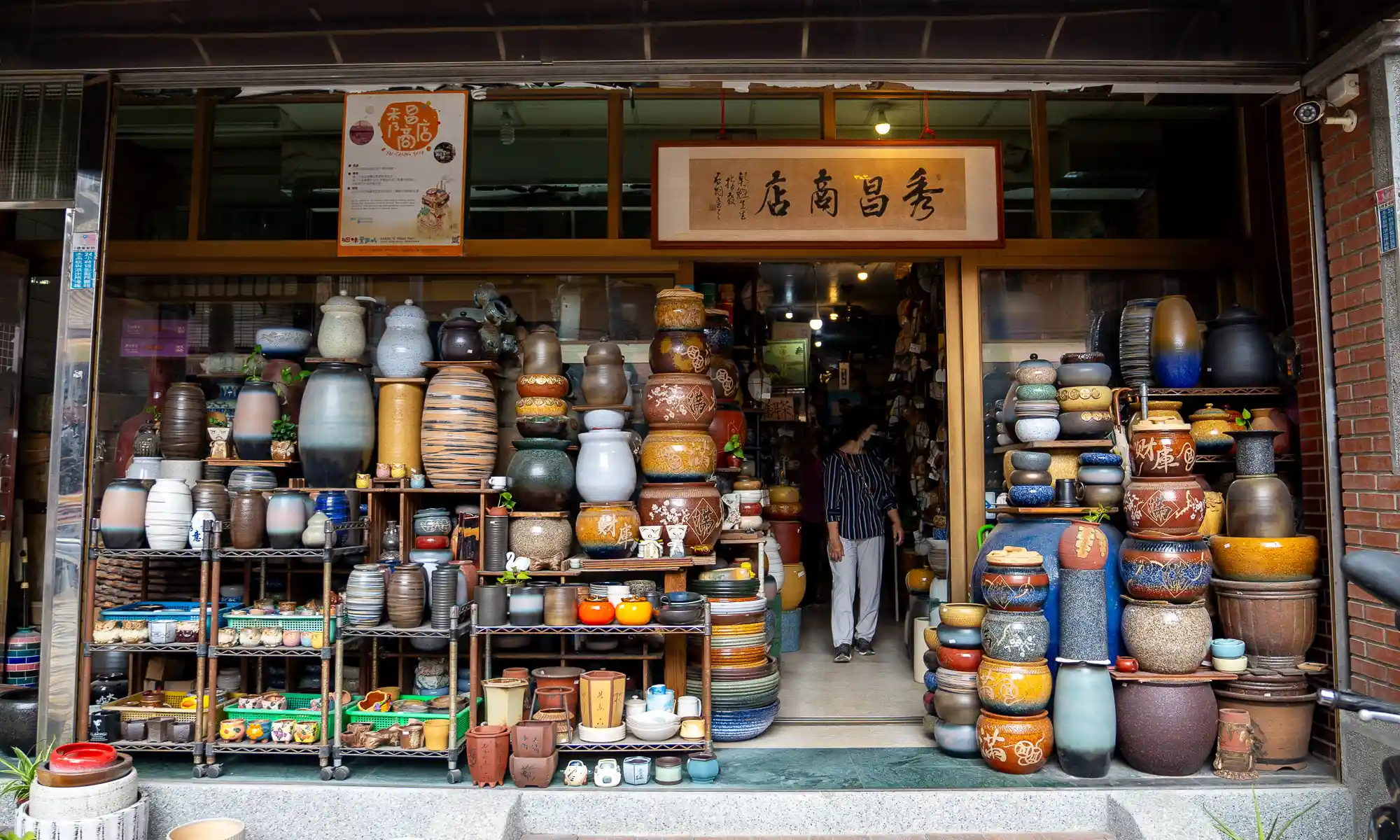A storefront on Yingge Old Street has ceramics stacked almost to the ceiling on display in front of the store.
