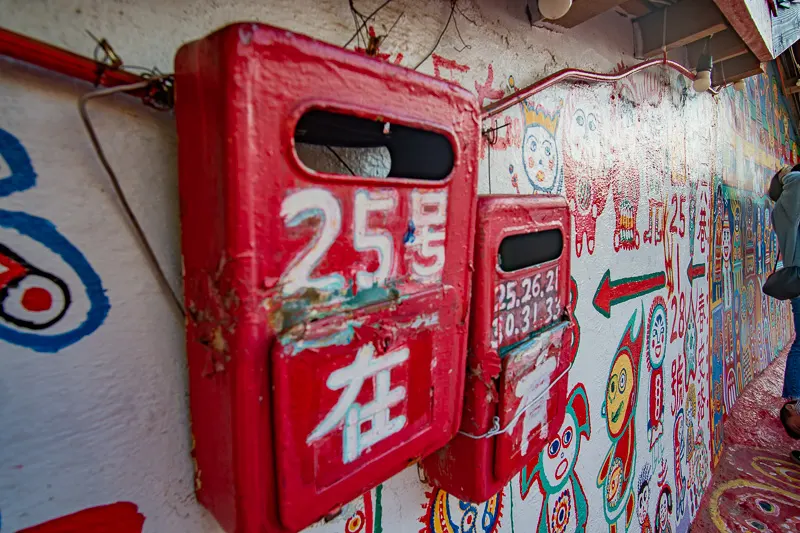 Old mailboxes have been painted over with humorous phrases, like: "I'm here".