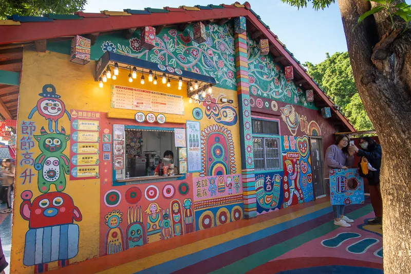 A shop sells drinks and snacks from within a colorful house in Taichung's Rainbow Village.