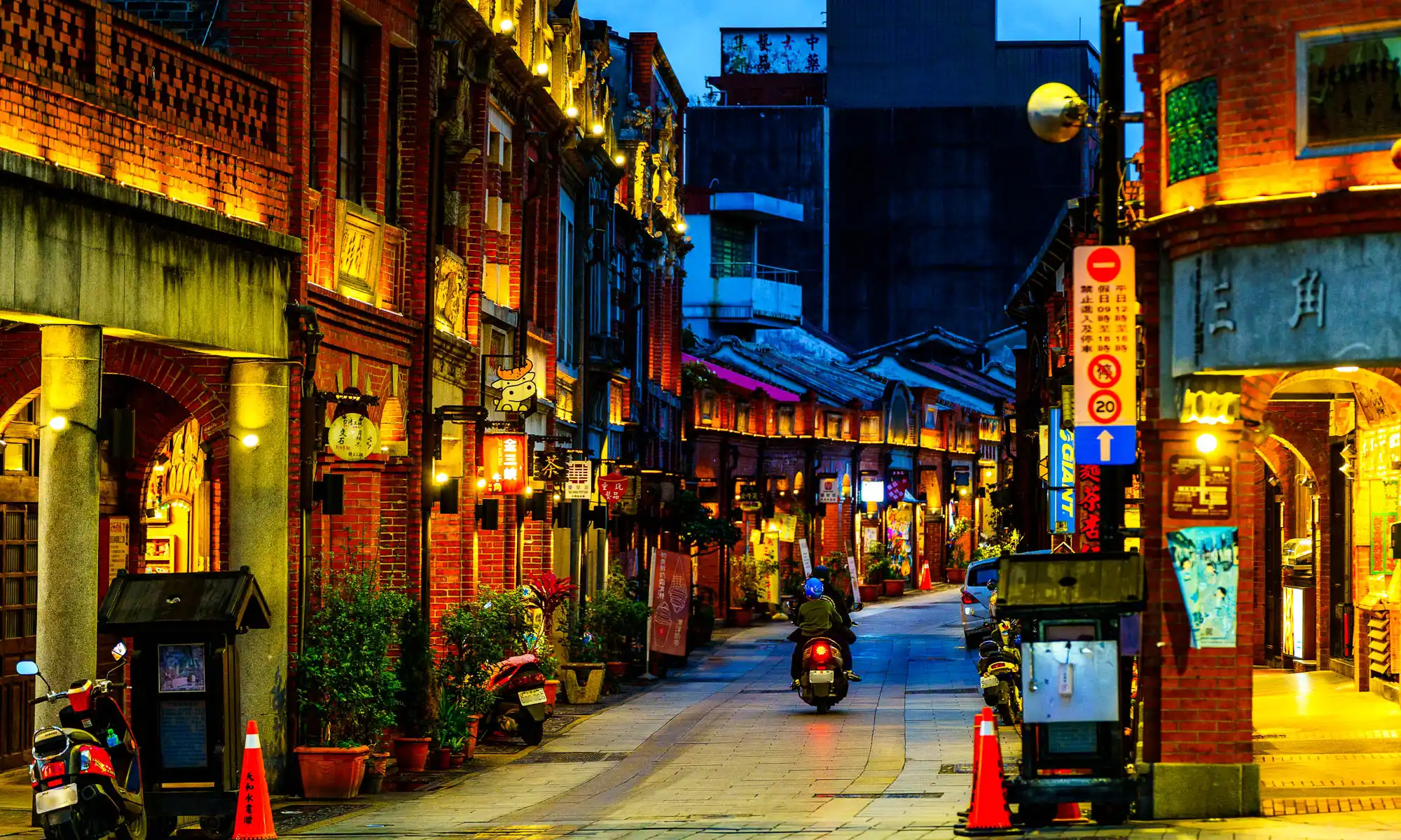 In the evening, the brick storefronts of Sanxia Old Street glow in the warm orange light of streetlamps.