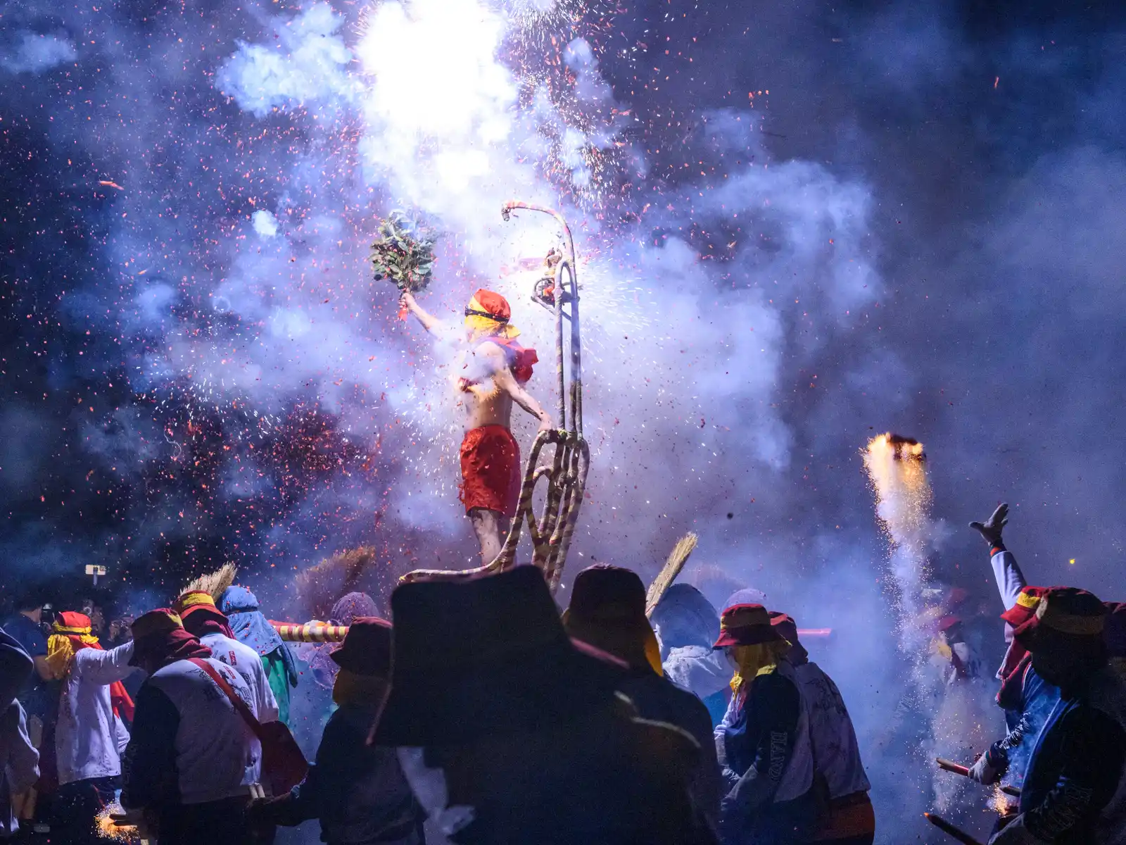 Volunteers toss firecrackers up at "Lord Handan".