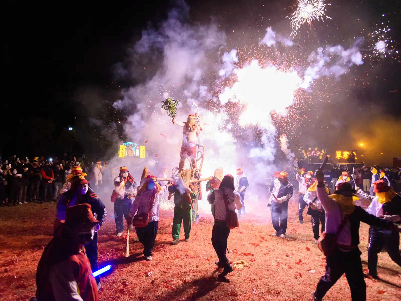 "Lord Handan" is paraded on a grassy field as temple volunteers bombard him with firecrackers.