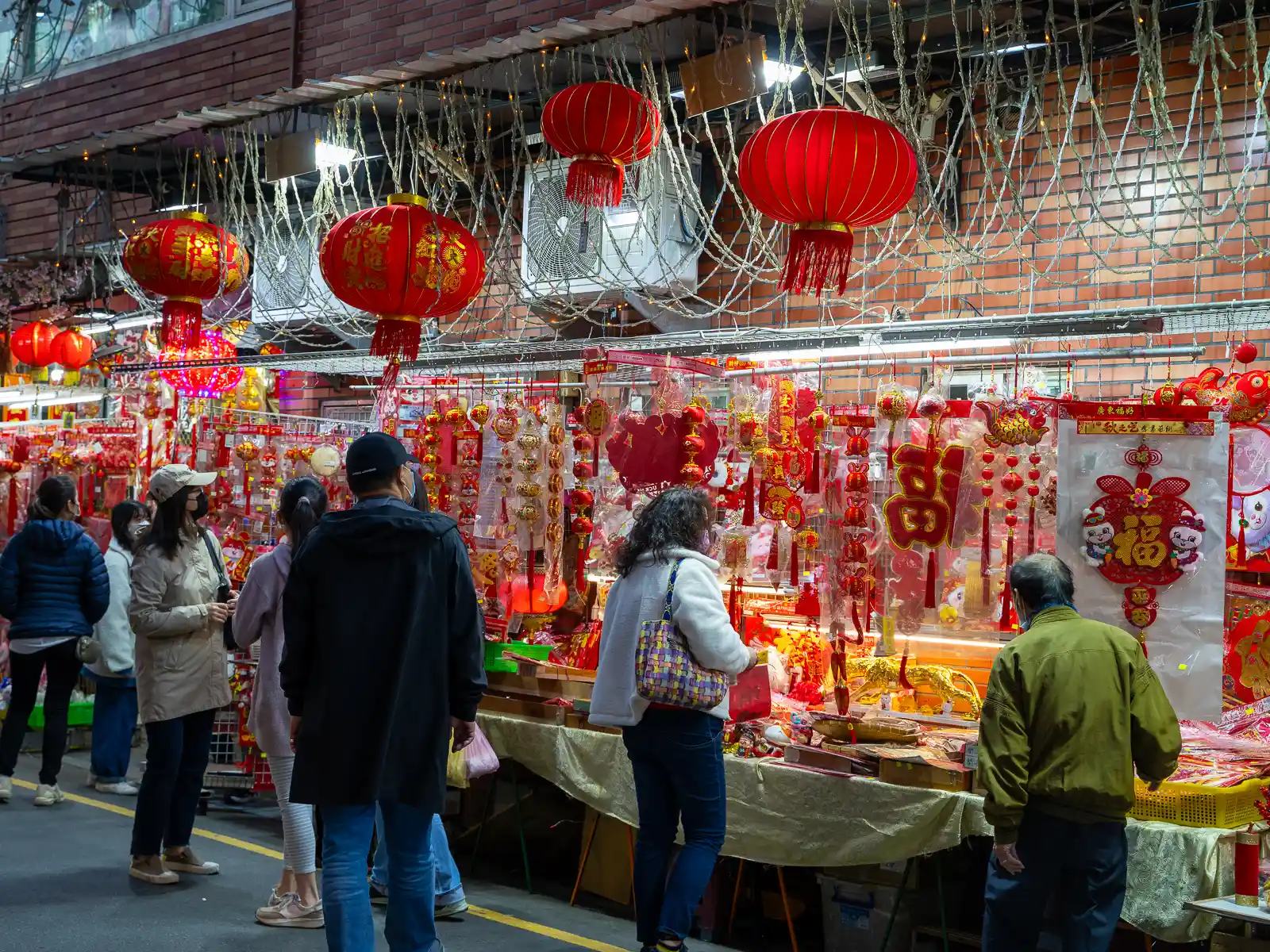 Red and gold New Year's decorations are being sold on the side of the street.
