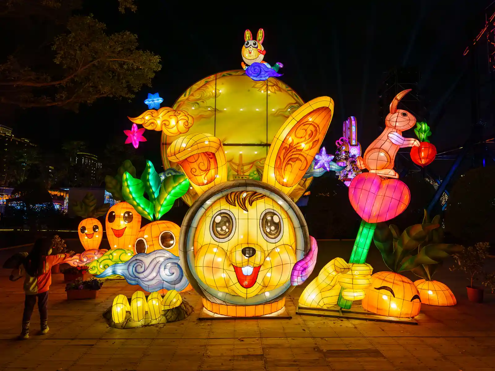 A large lantern display with an illuminated bunny, carrots, and other lanterns.