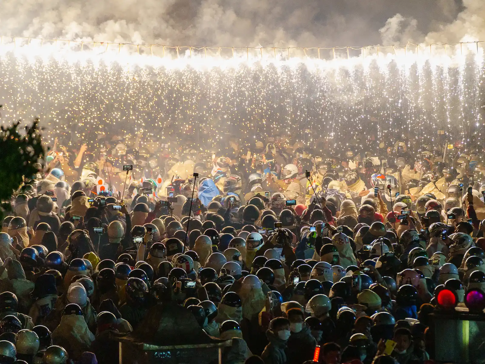 Sparklers suspended from a wire above the crowd illuminate the area.