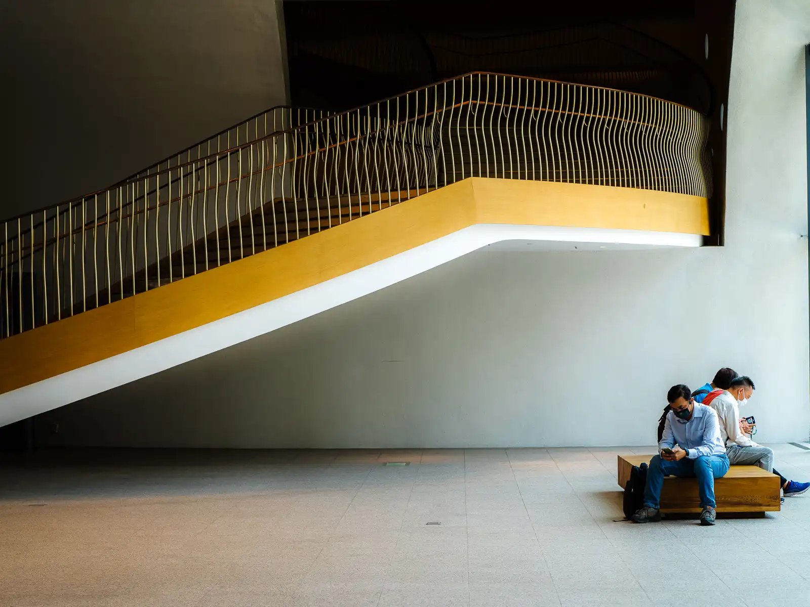 Visitors rest on benches in one of the large atriums of National Taichung Theater.