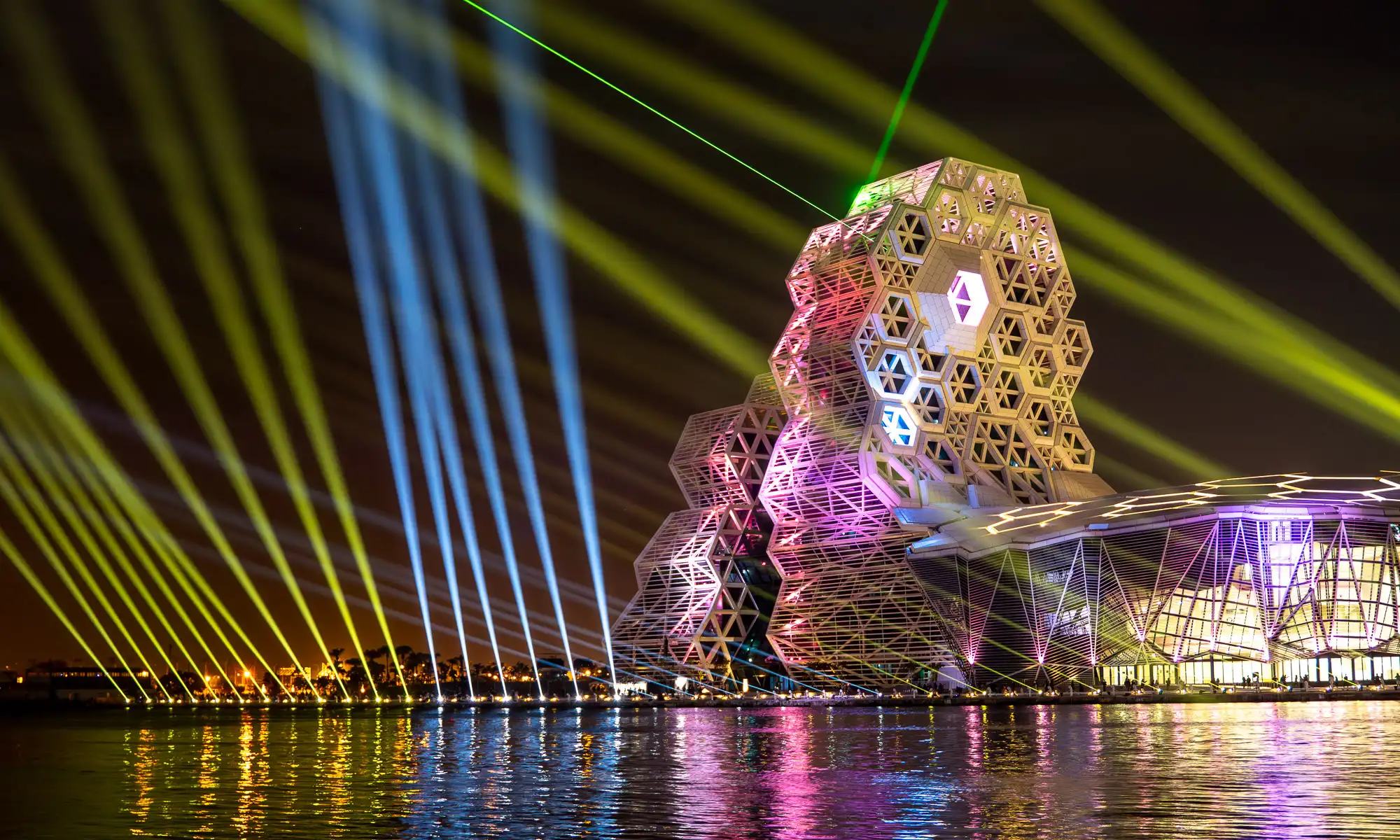 High-powered lights and lasers illuminate the sky around Kaohsiung Music Center during a spectacular light show.