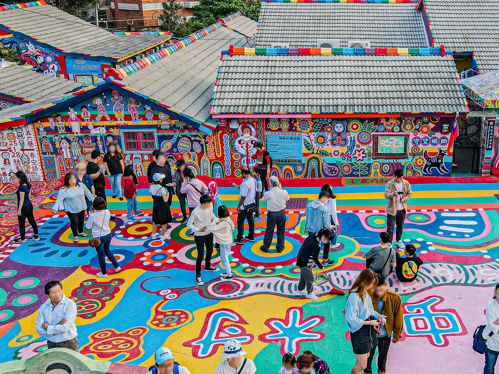 Tourists take photos and take in the surreal ambience of the colorful murals of Taichung's Rainbow Village