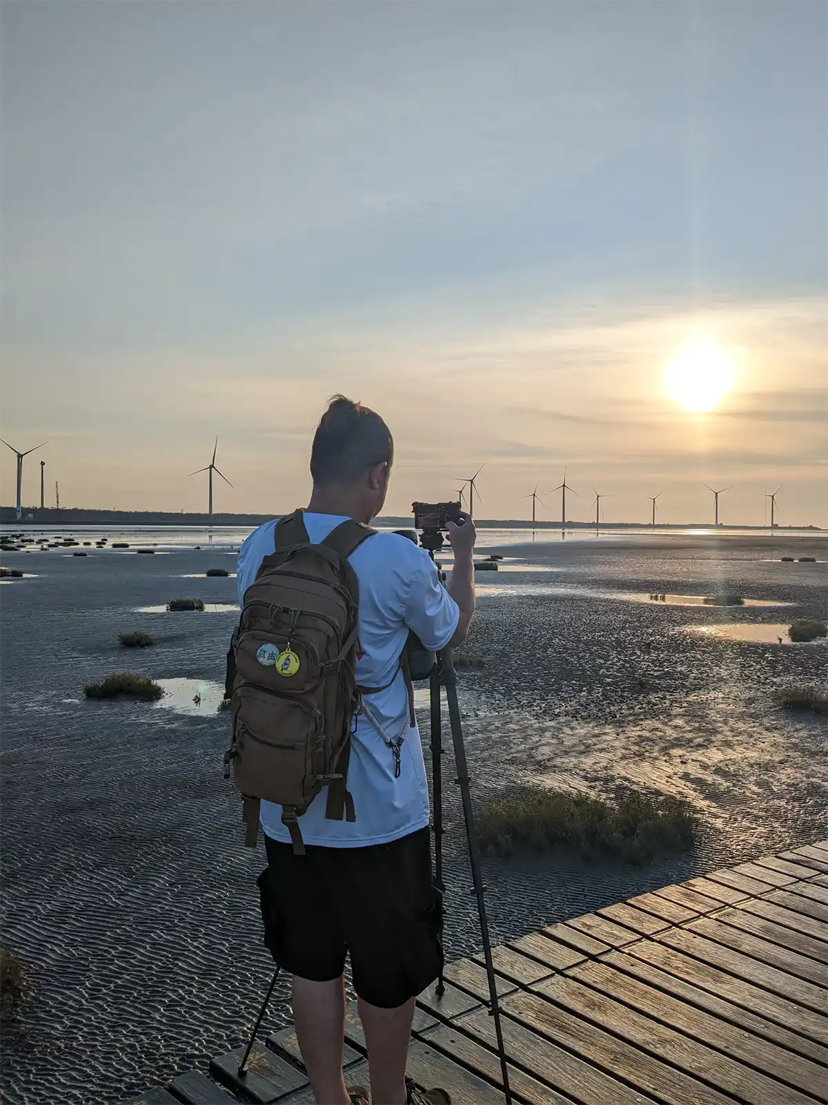 Photographer is taking the sunset photo of the Gaomei wetland.